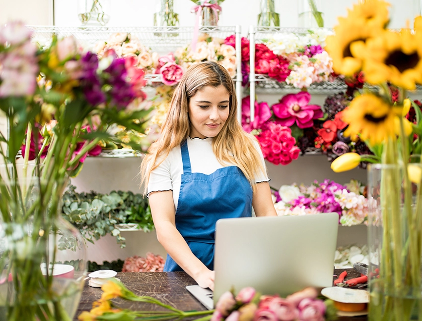 Ung dame som jobber i en blomsterforretning
